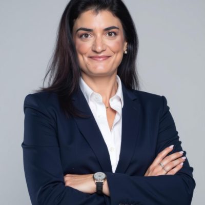 דיוקן עורכת הדין בחליפה כהה על רקע אפור בהיר
